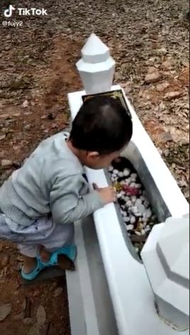 Bocah nangis sesegukan di hadapan makam sang ayah. (Tiktok/@fujy2)