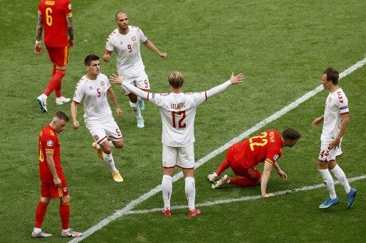 Pemain Denmark Kasper Dolberg menjebol gawang Wales yang dikawal Danny Ward dalam pertandingan babak 16 besar Euro 2020 yang digelar di Johan Cruijff Arena, Amsterdam, Belanda, Sabtu (26/6/2021). [AFP]