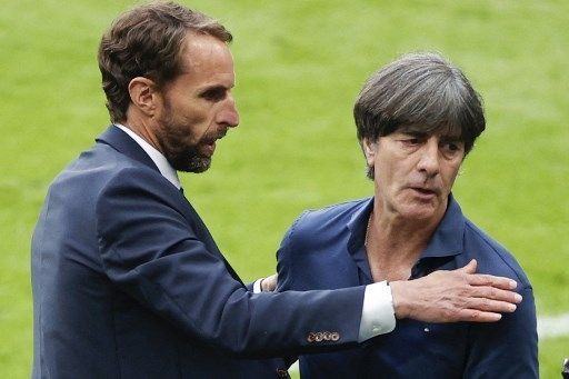 Pelatih Timnas Inggris Gareth Southgate menghampiri pelatih Jerman Joachim Loew usai kemenangan 2-0 The Three Lions atas Der Panzer di babak 16 besar Euro 2020 yang digelar di Stadion Wembley, Rabu (29/6/2021). [AFP]