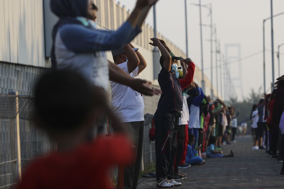 Warga mengikuti senam bersama di hari kedua PPKM Darurat di Jembatan Suramadu, Surabaya, Jawa Timur, Minggu (4/7/2021). [ANTARA FOTO/Didik Suhartono]