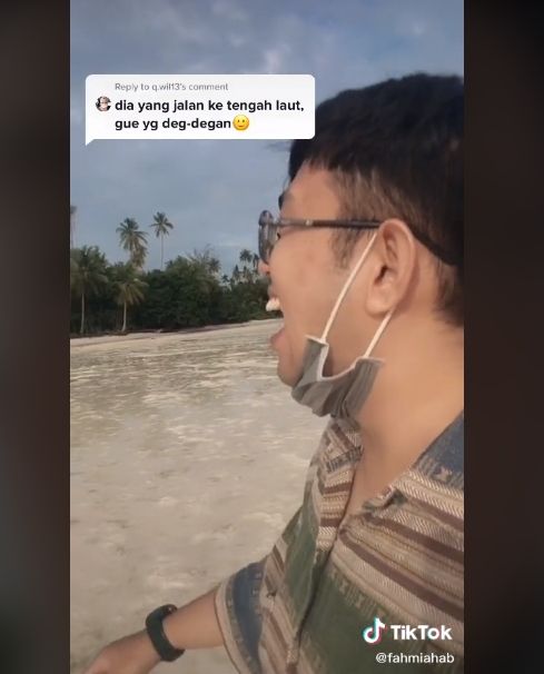 Pria ini tampak bahagia jalan di tengah laut yang surut. [fahmi habibie / TikTok]