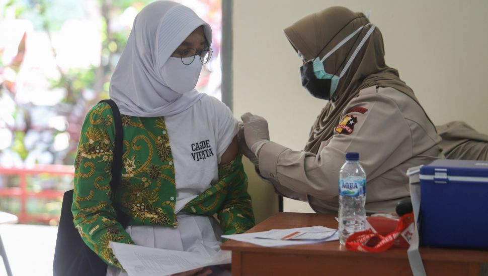 Pelajar saat menjalani vaksinasi Covid-19 di SMA Negeri 38, Jakarta Selatan, Kamis (15/7/2021). [Suara.com/Alfian Winanto]