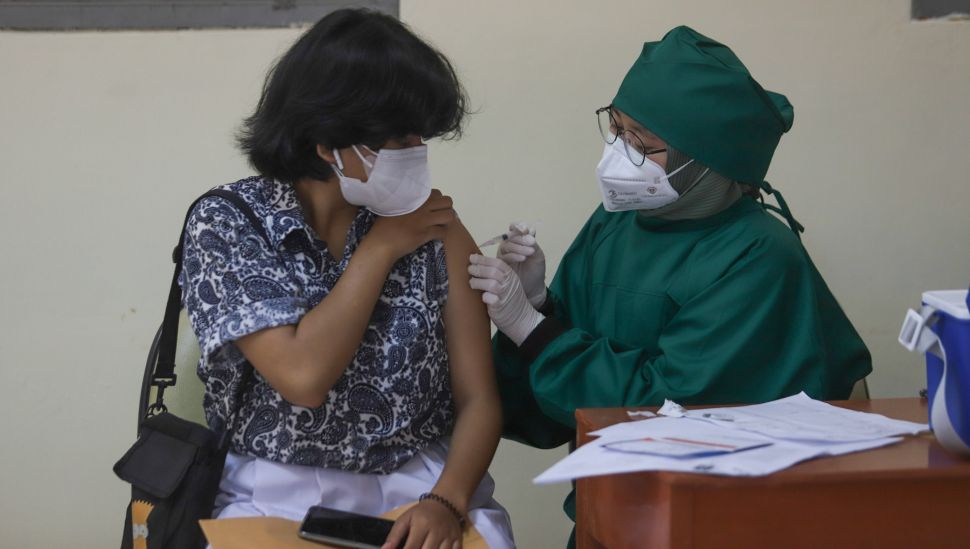 Pelajar saat menjalani vaksinasi Covid-19 di SMA Negeri 38, Jakarta Selatan, Kamis (15/7/2021). [Suara.com/Alfian Winanto]