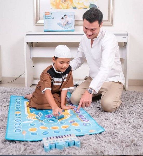 Christian Sugiono tampak tengah mengajarkan anaknya salat. Tapi foto ini diambil untuk kebutuhan iklan sebuah produk sajadah. [Instagram]