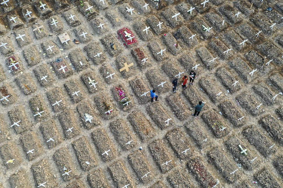 Foto udara warga berziarah di dekat pusara keluarganya di area pemakaman khusus COVID-19 di TPU Rorotan, Cilincing, Jakarta Utara, Kamis (15/7/2021).  ANTARA FOTO/M Risyal Hidayat
