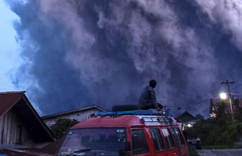 Residents observe Mount Sinabung spewing volcanic material in Kutarayat Village, Naman Teran, Karo, North Sumatra, Monday (19/7/2021).  BETWEEN PHOTOS / Ginting writers