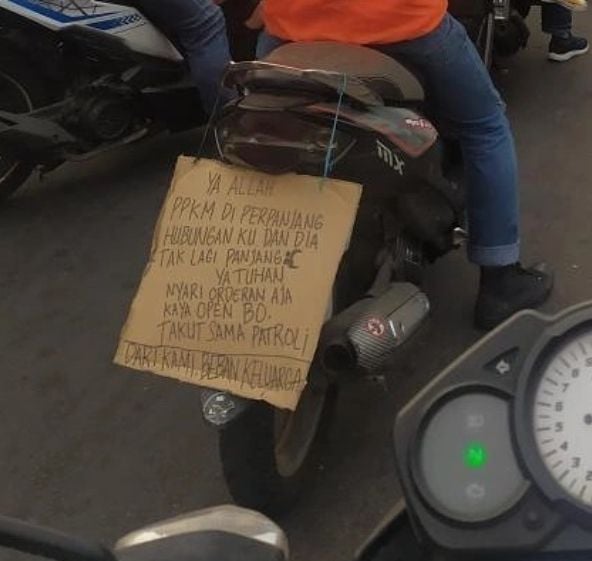 Tulisan curhatan driver ojol soal PPKM di belakang motornya. (Instagram/gojek24jam)