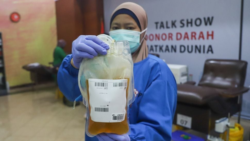 Petugas menunjukkan Plasma Konvalesen yang didonorkan warga di Kantor Palang Merah Indonesia (PMI) DKI Jakarta, Senen, Jakarta Pusat, Jumat (23/7/2021). [Suara.com/Alfian Winanto]