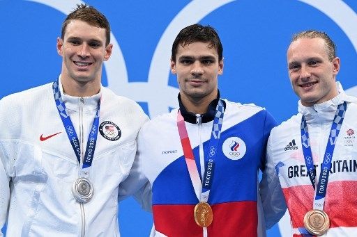 Pemenang gaya punggung 200 meter putra Olimpiade Tokyo (kiri-kanan): Ryan Murphy (perak), Evgeny Rylov (emas) dan Luke Greenbank (perunggu), berpose usai pertandingan Jumat (30/7/2021). [AFP]