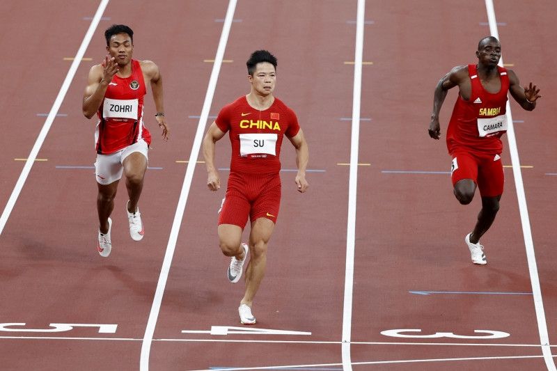 Sprinter Indonesia Lalu Muhammad Zohri (kiri) berlomba dengan pelari China Su Bingtian (tengah) dan Ebrima Camara asal Gambia (kanan) pada nomor lari 100 meter putra, heat 4, di Olympic Stadium, Tokyo, (Sabtu (31/7/2021). ANTARA/REUTERS/Phil Noble