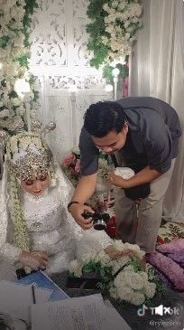 Viral pengantin wanita ujian online di meja akad setelah akad nikah. Aksi pengantin perempuan itu ditonton 19 juta kali.