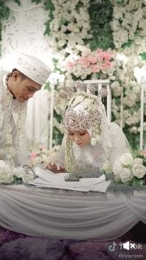 Viral pengantin wanita ujian online di meja akad setelah akad nikah. Aksi pengantin perempuan itu ditonton 19 juta kali.