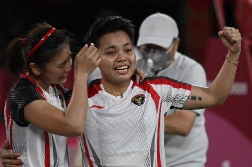 Pasangan ganda putri Apriyani Rahayu dan Greysia Polii dari Indonesia (kiri) merayakan setelah memenangkan pertandingan final bulu tangkis ganda putri melawan pasangan China Jia Yifan dan Chen Qingchen di Olimpiade Tokyo 2020 di Musashino Forest Sports Plaza di Tokyo pada 2 Agustus 2021.Alexander NEMENOV / AFP