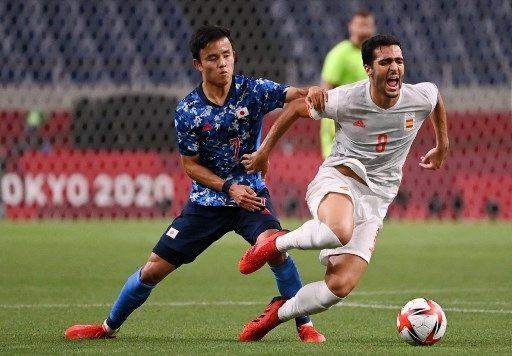 Pemain Jepang Takefusa Kubo melanggar pemain Spanyol dalam pertandingan semifinal Olimpiade Tokyo di Saitama Stadium, Selasa (3/8/2021). [AFP]