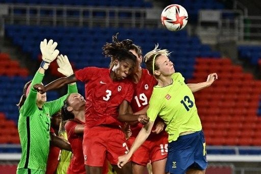 Pemain Swedia Amanda Ilestedt berebut bola dengan pemain Kanada dalam laga final sepak bola putri Olimpiade Tokyo di Stadion Yokohama, Jumat (6/8/2021). [AFP]