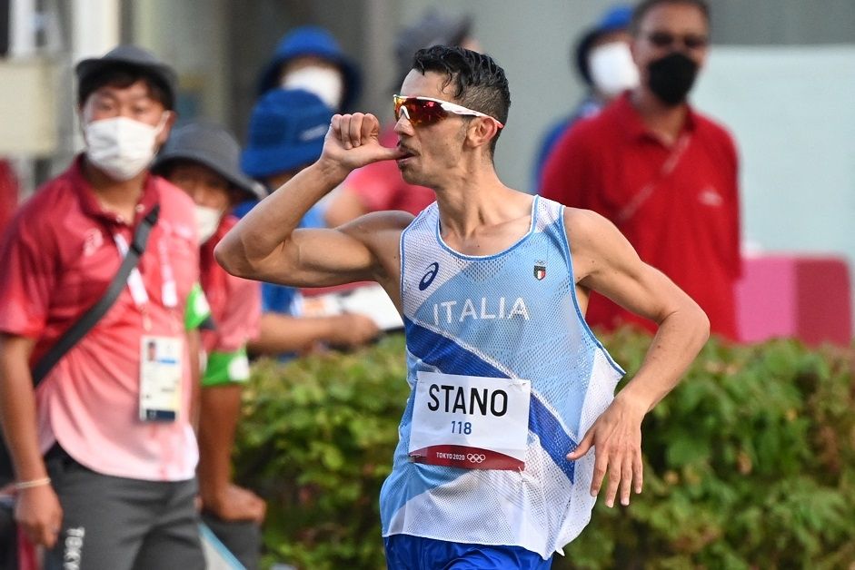 Atlet Italia Massimo Stano dengan pose Gear Third ala Monkey D Luffy tokoh One Piece saat masuk garis finish dan meraih medali emas jalan cepat 20 km Olimpiade Tokyo. [Charly TRIBALLEAU / AFP]