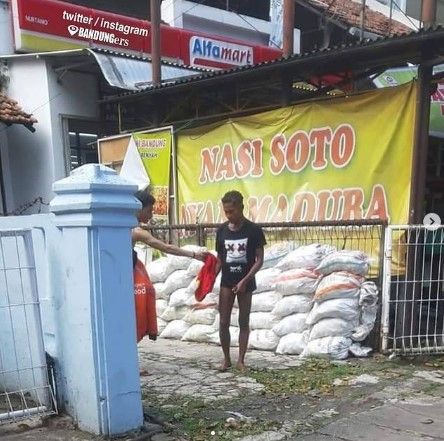 Viral driver Shopee Food berikan celana kolor untuk ODGJ atau orang gila di Bandung. Si driver Shopee Food itu melepas celananya di balik tembok lahan kosong. (@Bandung.Banget)