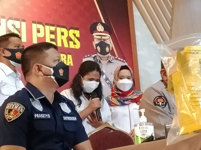 Sosok EO, nakes yang suntikkan vaksin kosong di daerah Pluit, Jakarta Utara tampak menangis mengaku menyesal saat dihadirkan polisi di Mapolrestro Jakarta Utara, Selasa (10/8/2021). (Suara.com/Arga)