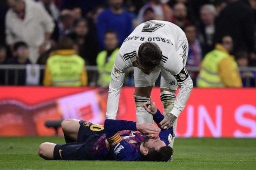 Sergio Ramos menghentikan Lionel Messi dalam laga El Clasico antara Real Madrid vs Barcelona. [AFP]