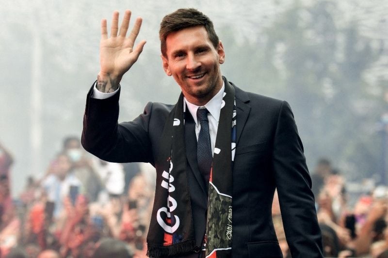 Pemain baru Paris Saint-Germain Lionel Messi memberikan salam hormat kepada para pendukung PSG di luar Stadion Parc des Princes setelah konferensi pers pertamanya sebagai pemain PSG di Paris pada 11 Agustus 2021. (AFP/BERTRAND GUAY)