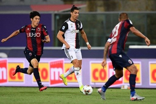 Aksi bek Bologna asal Jepang, Takehiro Tomiyasu saat berhdapan dengan bintang Juventus, Cristiano Ronaldo. (MIGUEL MEDINA / AFP)