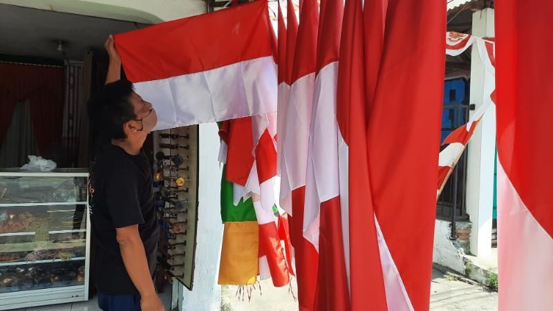 Pedagang Bendera Merah Putih, Endang merapikan bendera yang dia jual di toko miliknya Jalan Wonosari, Kalurahan Tegaltandan, Kapanewon Banguntapan, Kabupaten Bantul, Senin (16/8/2021). [Muhammad Ilham Baktora / SuaraJogja.id]