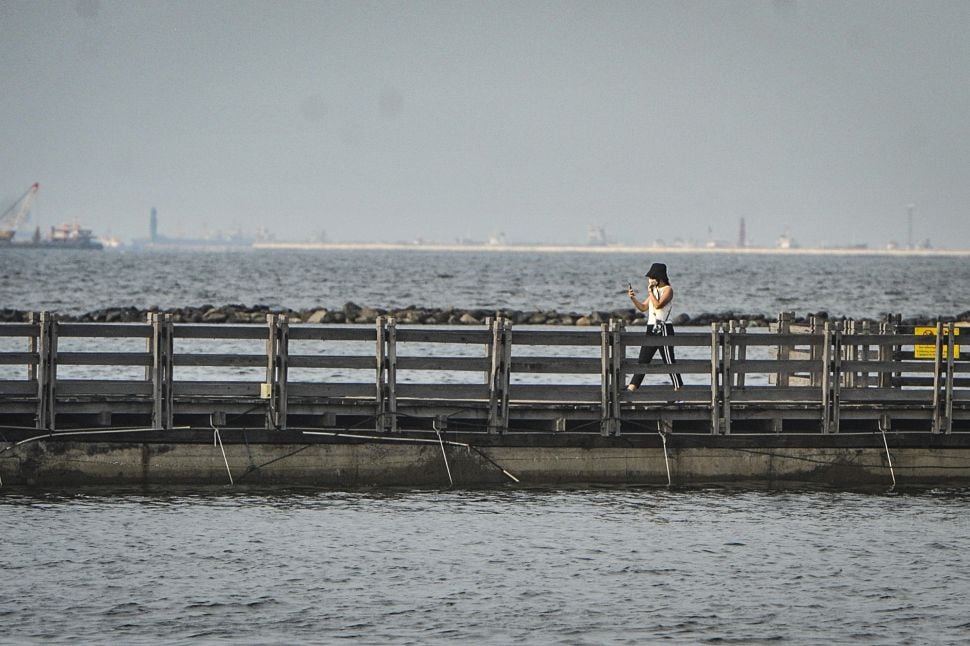 Seorang pengunjung berjalan di kawasan Taman Impian Jaya Ancol, Jakarta, Rabu (18/8/2021). ANTARA FOTO/Aprillio Akbar