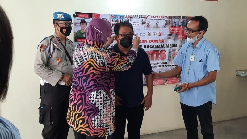 Ketua Primkoppol Polresta Yogyakarta, AKBP Isrowiyah (batik merah muda) memakaikan kacamata kepada seorang driver ojol saat pemberian kacamata medis dalam acara Gerakan Donasi Sejuta Frame Kacamata Medis, MGI di Mapolresta Yogyakarta, Jumat (27/8/2021). [Muhammad Ilham Baktora / SuaraJogja.id]