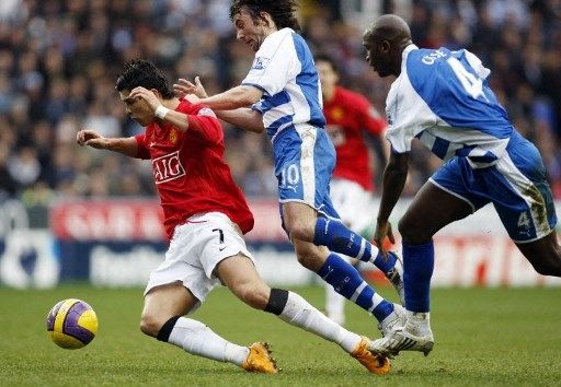 Pemain Manchester United Cristiano Ronaldo berebut bola dengan pemain Reading Stephen Hunt (tengah) dan Kalifa Cisse dalam pertandingan Liga Premier Inggris di Madejski Stadium, 19 Januari 2008. [AFP]