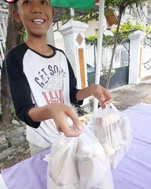 Bocah belajar sambil jualan nasi bungkus di pinggir jalan. (Tiktok/@masfais_1987)