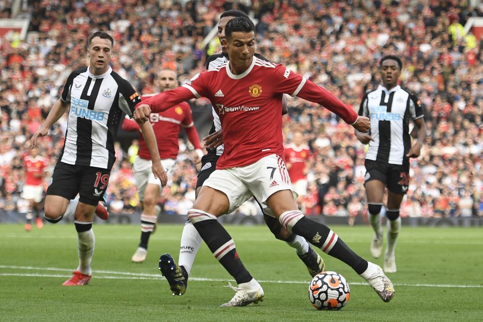 Striker Manchester United Cristiano Ronaldo menembak untuk mencetak gol kedua mereka selama pertandingan sepak bola Liga Premier Inggris antara Manchester United dan Newcastle di Old Trafford, Manchester, Inggris, Sabtu (11/9/2021). [Oli SCARFF / AFP]