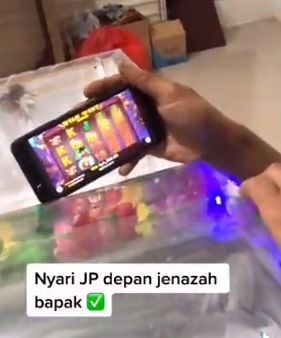 Pemuda main judi online di depan jenazah ayah. (Twitter/KomisiJudi)