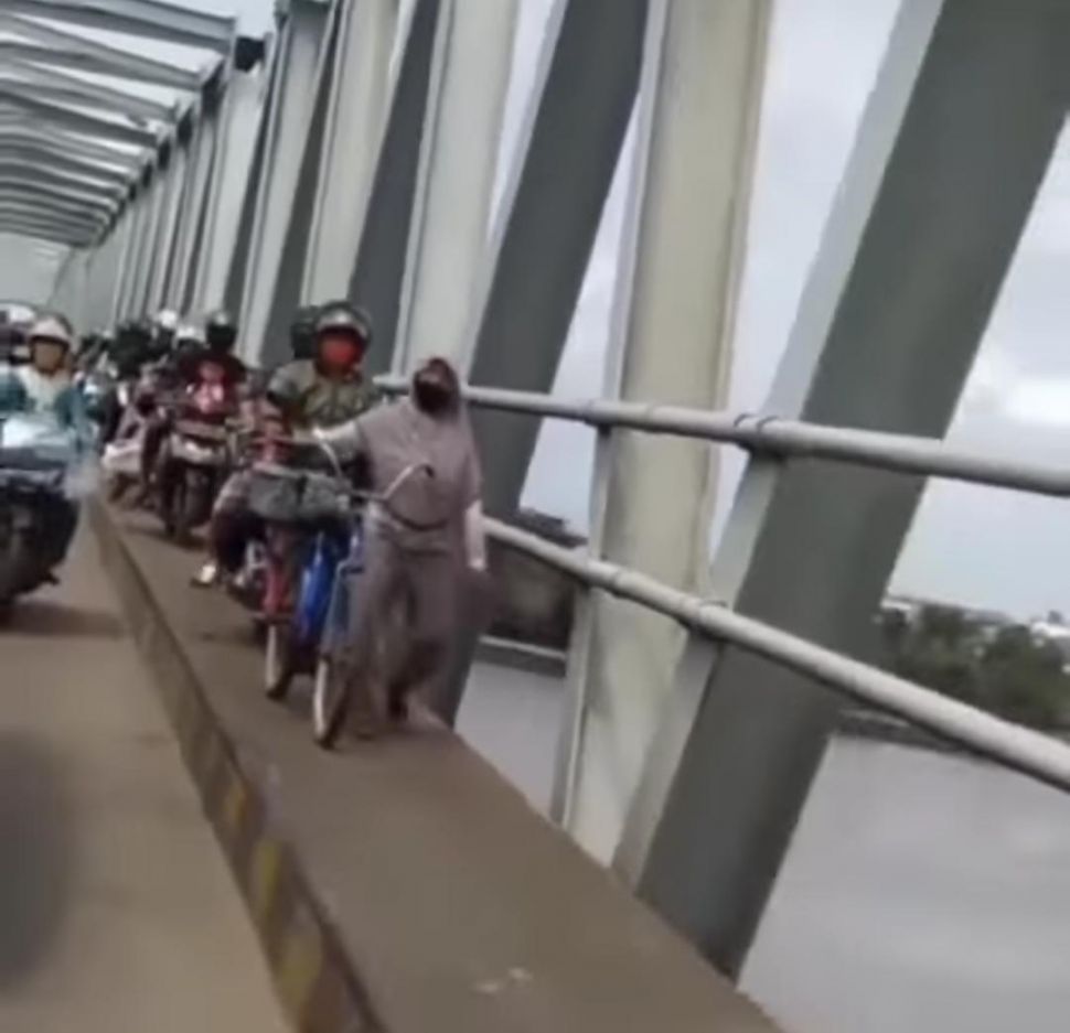 Viral pemotor hindari macet malah terjebak macet di trotoar jembatan. Pilian salah itu lantaran ada sosok perempuan berjilbab yang berjalanan di trotoar.