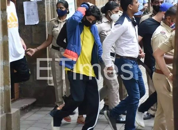 Putra Shah Rukh Khan, Aryan Khan (mengenakan jaket biru) ketika keluar dari pengadilan untuk menjalani persidangan. [Yogen Shah]