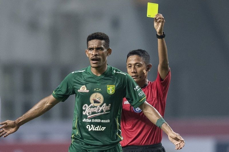 Pesepakbola Persebaya Surabaya, Ricky Kambuaya (kiri) mendapatkan kartu kuning dari wasit pada laga BRI Liga 1. [ANTARA FOTO/M Risyal Hidayat]