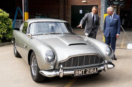 Daniel Craig memaparkan kerennya Aston Martin DB5 kepada Prince of Wales, Pangeran Charles (kanan). Sang pangeran bertemu dengan pemeran Agen 007 saat tur ke lokasi syuting film James Bond ke-25 di Pinewood Studios, Iver Heath, barat London (20/6/2019) [AFP/POOL/Niklas Halle'n].