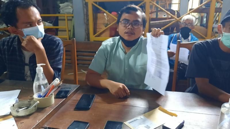 Staff Advokasi LBH Yogyakarta, Budi Hermawan menunjukkan surat laporan polisi yang ditujukan kepada warga Jomboran yang menolak pertambangan di kali Progo saat ditemui di Kantor Walhi Yogyakarta, Senin (11/10/2021). [Muhammad Ilham Baktora / SuaraJogja.id]