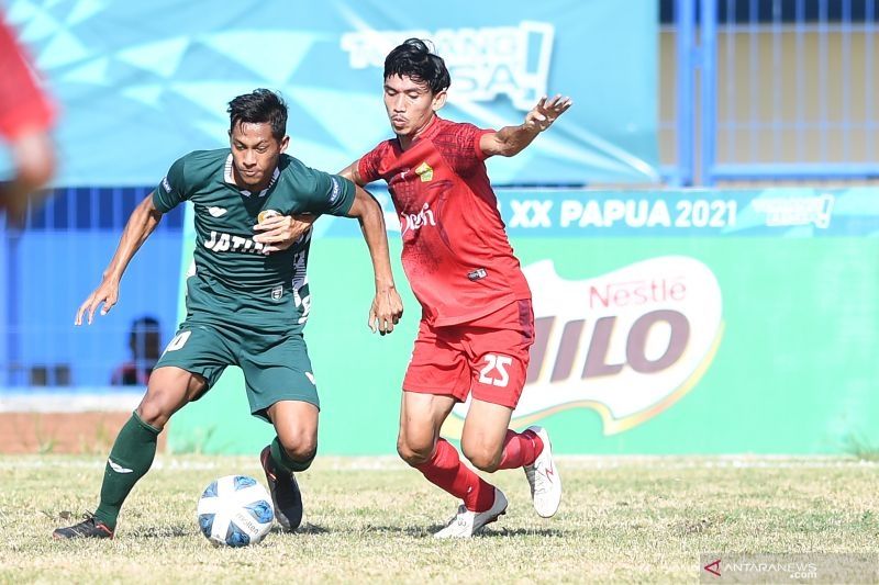 Pesepak bola Jawa Timur Muhamad Faisol Yunus (kiri) berebut bola dengan pesepak bola Aceh Muzakir (kanan) pada Semifinal Sepak Bola Putra PON Papua di Stadion Barnabas Youwe, Sentani, Kabupaten Jayapura, Papua, Selasa (12/10/2021). Tim Aceh menang atas tim Jawa Timur dengan skor 2-1. ANTARA FOTO/Zabur Karuru (ANTARA FOTO/ZABUR KARURU)