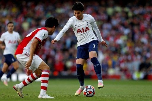 Pemain Arsenal Takehiro Tomiyasu berebut bola dengan pemain Tottenham Hotspur Son Heung-min dalam pertandingan Liga Premier, 26 September 2021. [AFP]