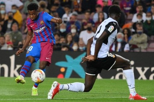 Pemain Barcelona Ansu Fati menjebol gawang Valencia dalam pertandingan pekan ke-9 La Liga di Camp Nou, Senin (18/10/2021). [AFP]