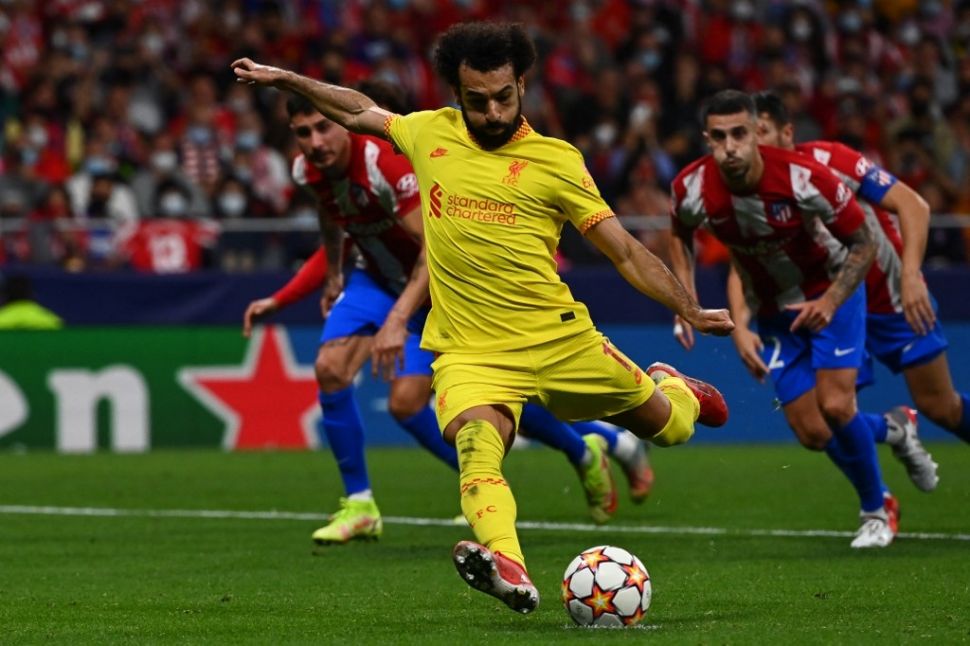 Aksi Mohamed Salah saat Liverpool mendapatkan hadiah penalti di laga lanjutan Liga Champions menghadapi tuan rumah Atletico Madrid di Wanda Metropolitano Stadium, Rabu (20/10/2021) dini hari WIB. The Reds menang 3-2. (foto: AFP)