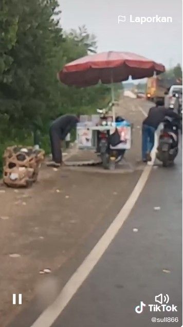 Viral pedagang melakukan salat di pinggir jalan, pengendera sepeda motor pun memberikan penghormatan dengan menuntun motornya. [TikTok]