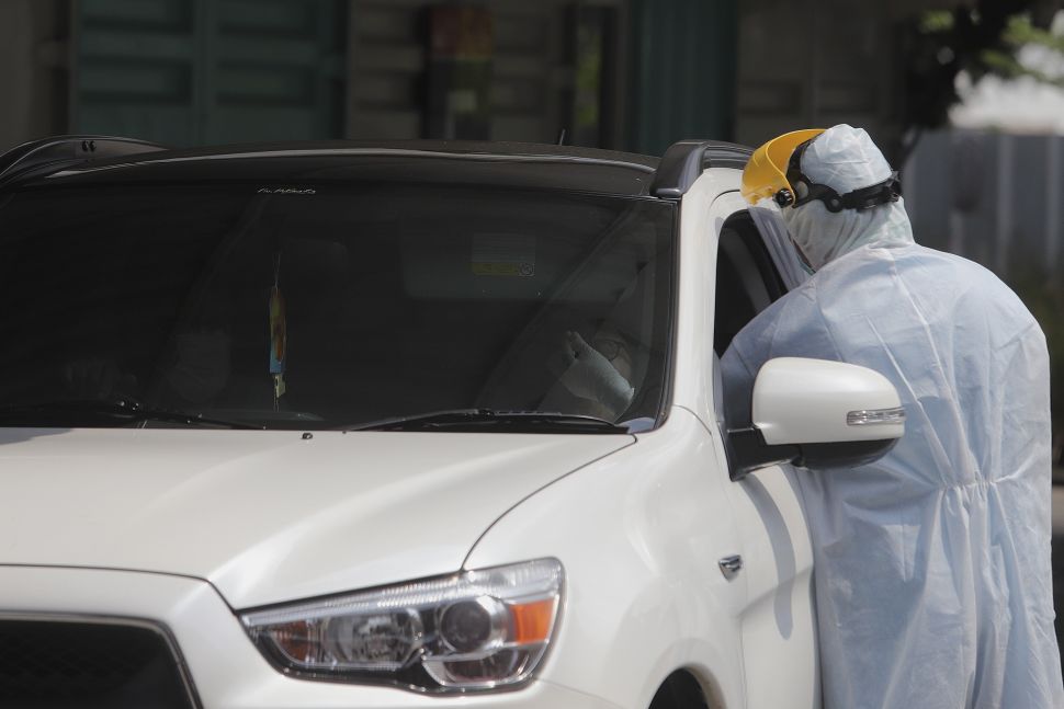 Petugas kesehatan melakukan tes usap (swab test) PCR secara 'drive thru' di Jakarta, Jumat (29/10/2021). [Suara.com/Angga Budhiyanto]