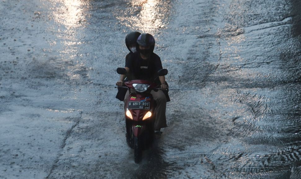 Pengendara motor melintas saat hujan di Jalan Gatot Subroto, Jakarta, Senin (1/11/2021). [Suara.com/Alfian Winanto]