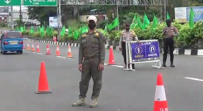 Petugas berjaga di lokasi penyekatan ganjil genap, Minggu (14/11/2021). [Bogordaily.net]