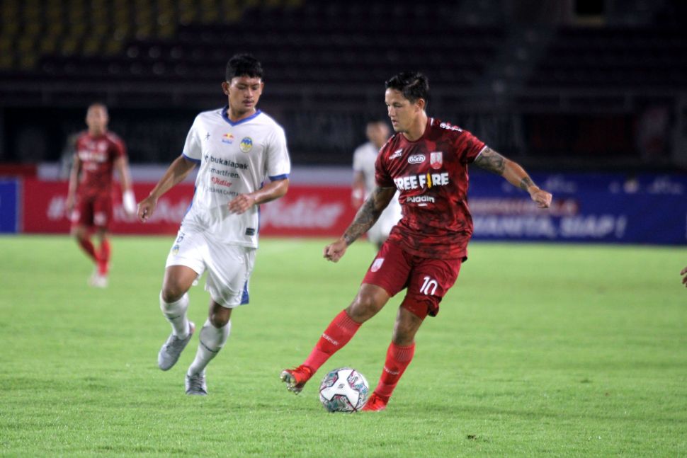 Striker Persis Solo, Irfan Bachdim berusaha melewati adangan pemain PSIM Yogyakarta, Ahmad Baasithdalam lanjutan Liga 2 musim 2021 di Grup C usai dikalahkan PSIM Yogyakarta di Stadion Manahan, Senin (15/11/2021). [Suara.com/Ronald Seger Prabowo]