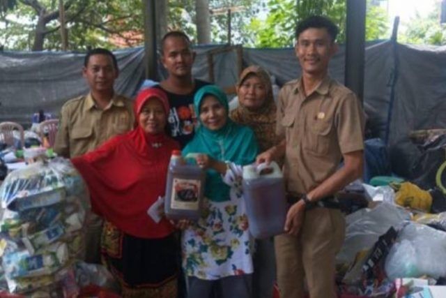 Warga menyalurkan minyak jelantah ke petugas DLH Kota Tangerang, Rabu (17/11/2021). [Muhammad Jehan Nurhakim/Suara.com]