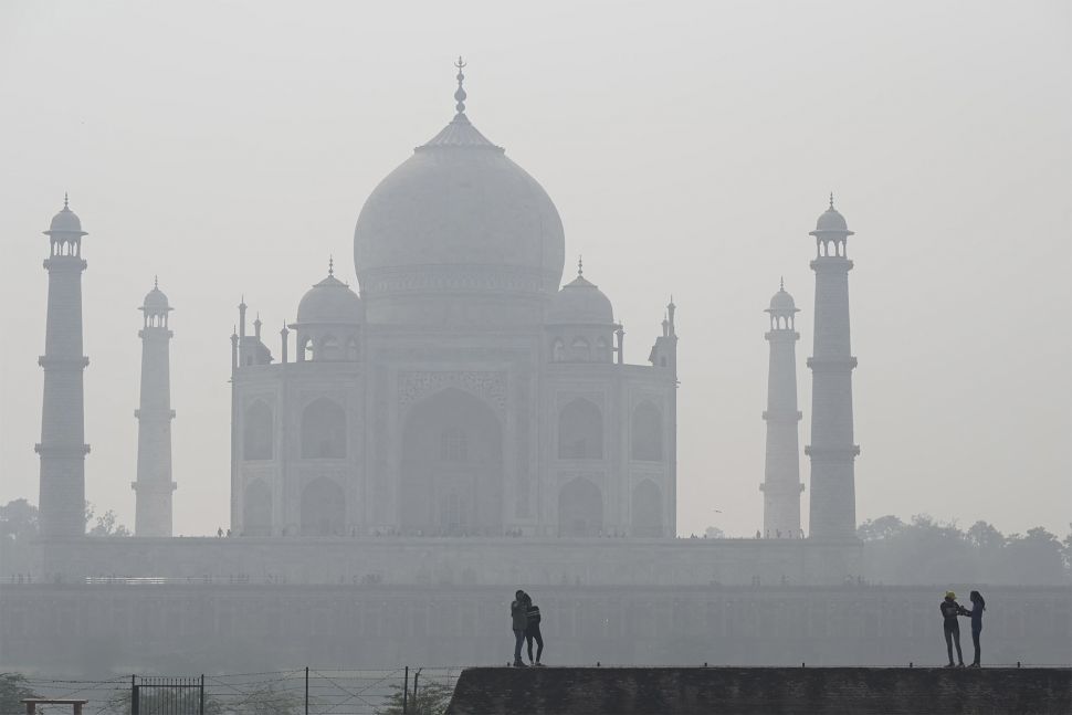 Warga mengunjungi kompleks Mehtab Bagh di belakang Taj Mahal saat kondisi kabut asap di Agra, India, pada (16/11/2021). [SAJJAD HUSSAIN / AFP]