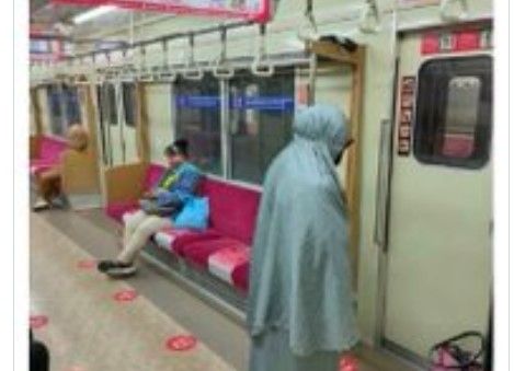 Perempuan salat di kereta (twitter.com/ainunnajib)