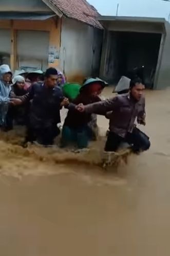 Aksi totalitas polisi saat mengevakuasi emak-emak di tengah banjir. )(Instagram/polres.gunungkidul)